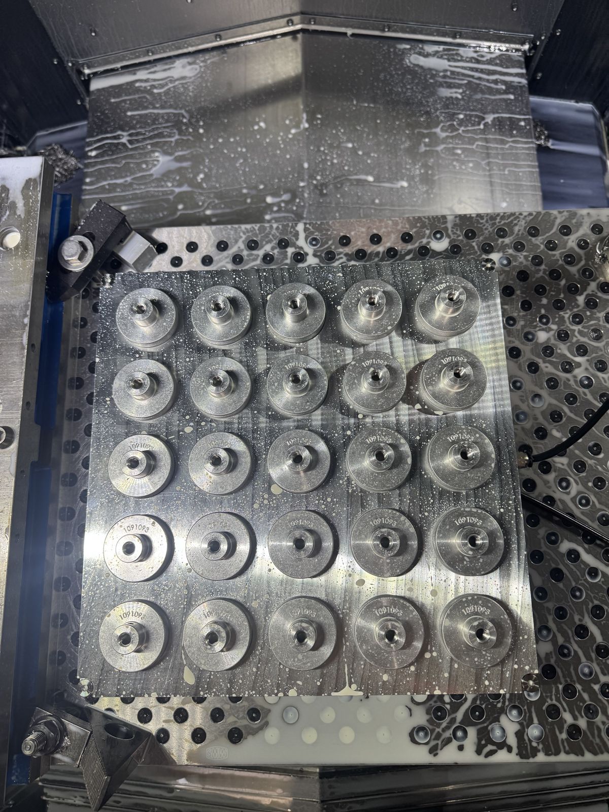 Twenty-five knurled parts on a fixture plate