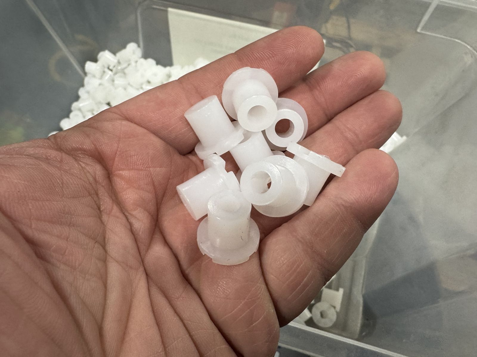 White molded plastic bushings in hand
