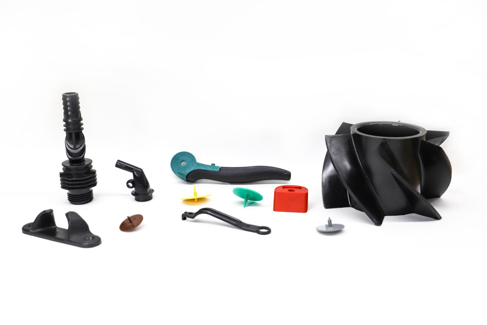 A range of injection molded plastic parts in black, green, teal and red