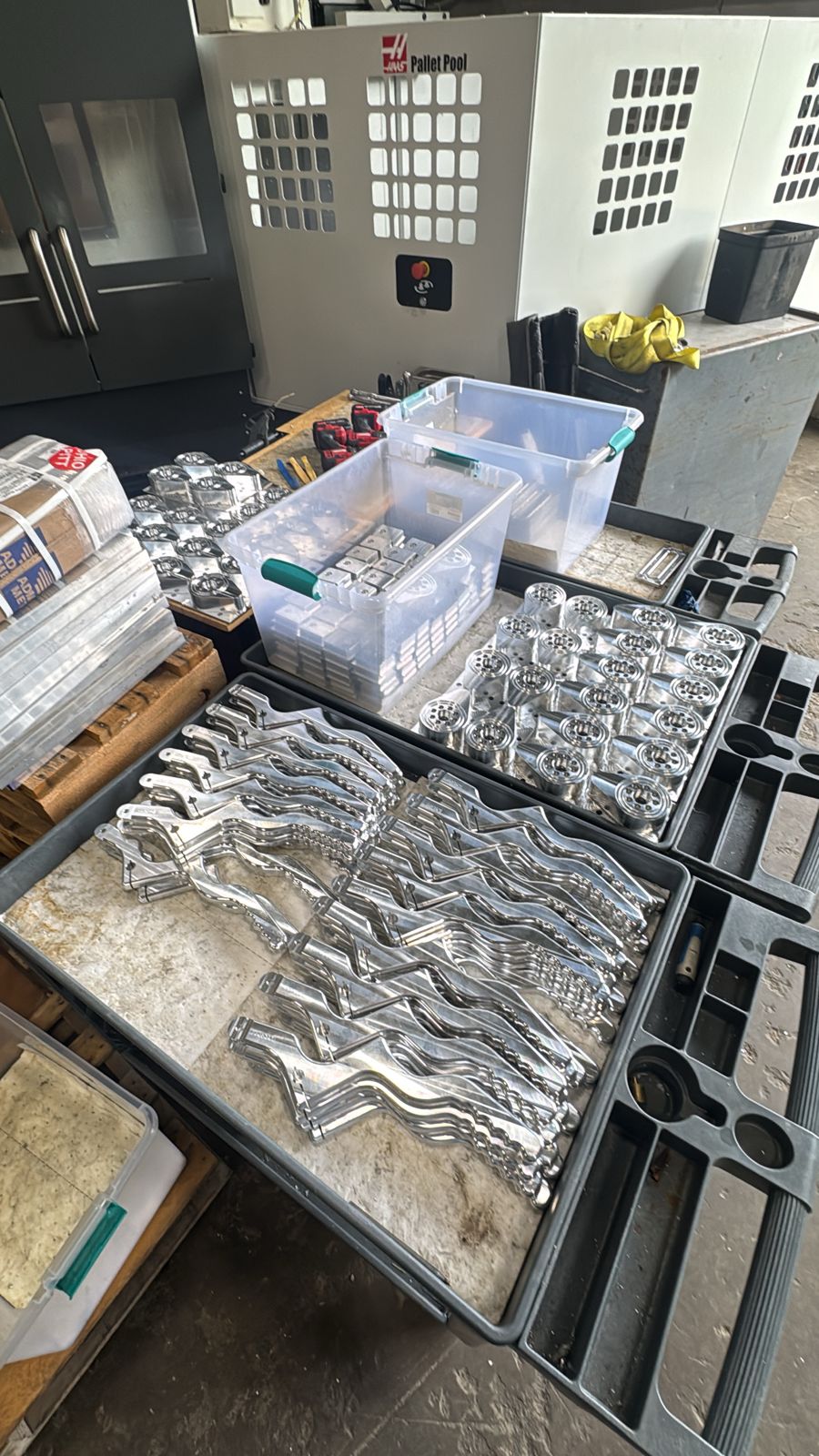 Trays of finished machined parts in front of the Haas pallet pool